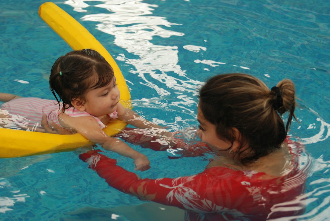 Child participating in aquatic therapy with an adult in a swimming pool