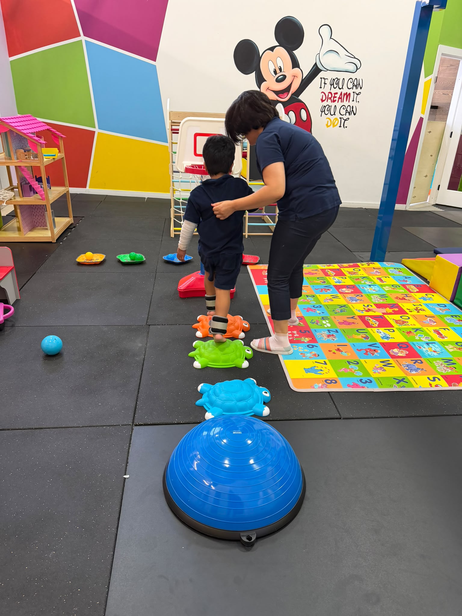 Therapist supporting a child during a sensory and motor activity at My Empower Therapy