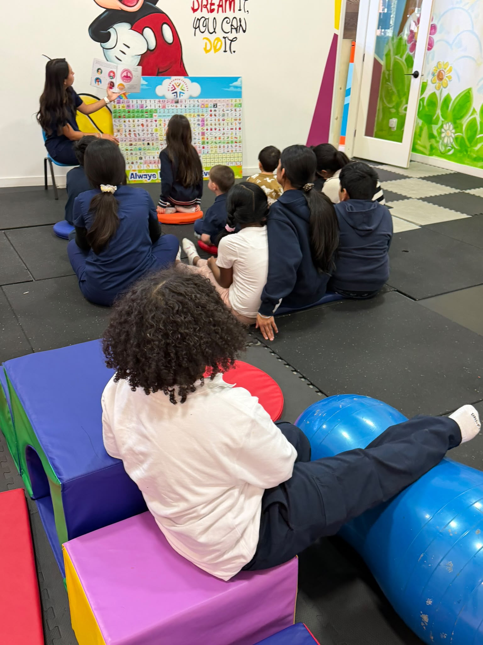 Educator supporting children in a small-group learning environment at Empower Academy